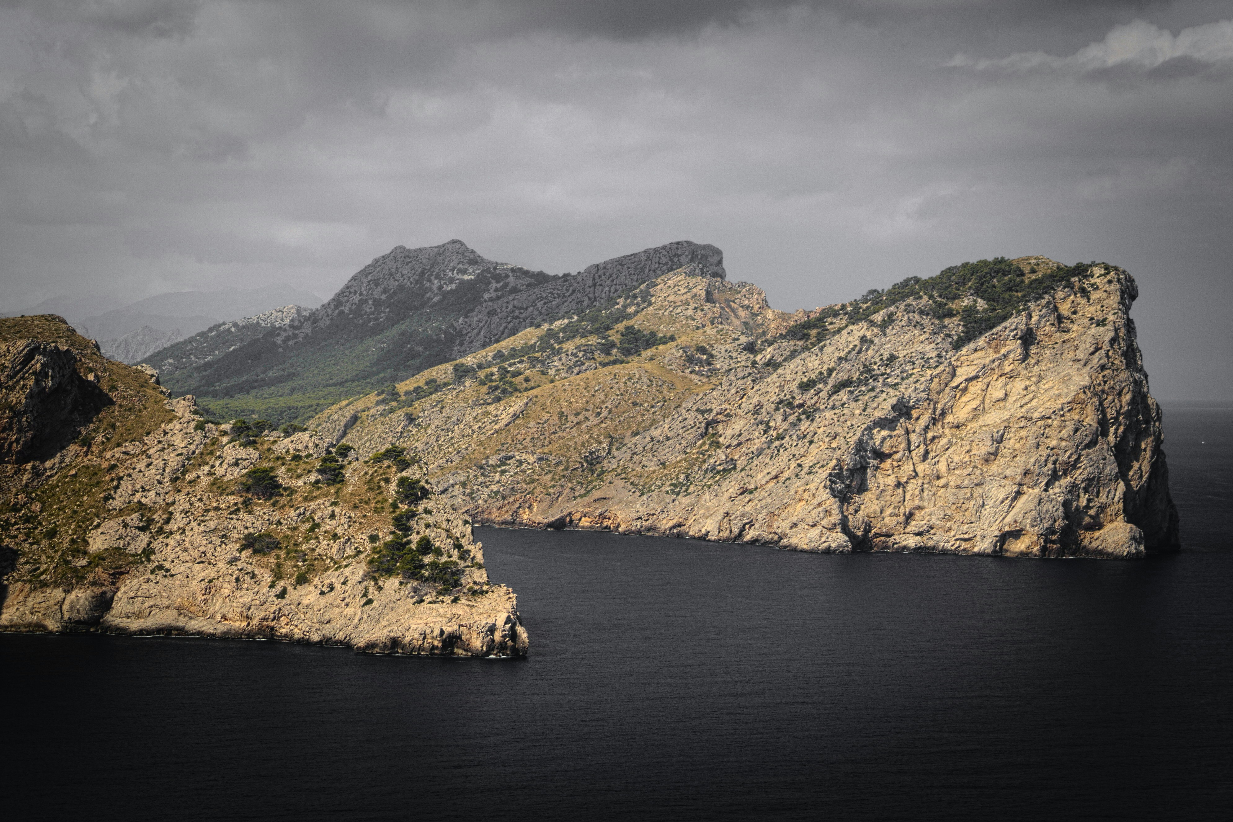 high angle photography of mountain cliff near body of water